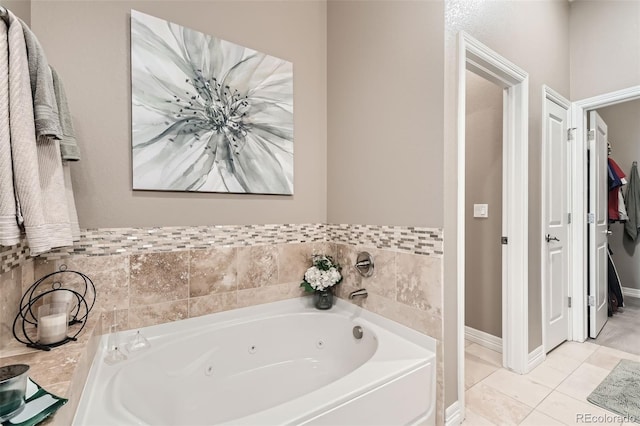 full bathroom featuring a jetted tub, baseboards, and tile patterned floors