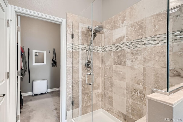 full bathroom featuring a shower stall and baseboards