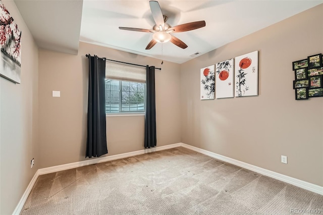 spare room featuring a ceiling fan, carpet, visible vents, and baseboards