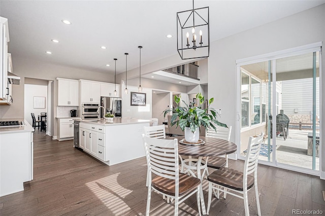 dining room with dark wood-style flooring, recessed lighting, and a notable chandelier