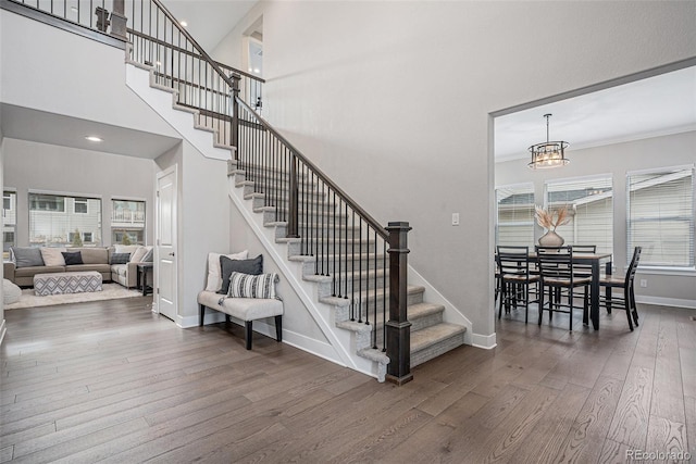 6733 S Waterloo Ct, Aurora, CO 80016 - stairway featuring wood-type flooring, baseboards, recessed lighting, a chandelier, and a high ceiling