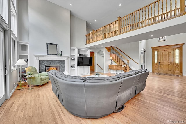 6681 Flintwood Rd, Parker, CO 80138 - living room with a towering ceiling, a tile fireplace, stairway, wood finished floors, and arched walkways