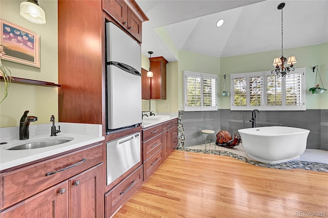 6681 Flintwood Rd, Parker, CO 80138 - full bath featuring wood finished floors, vanity, a soaking tub, wainscoting, and lofted ceiling