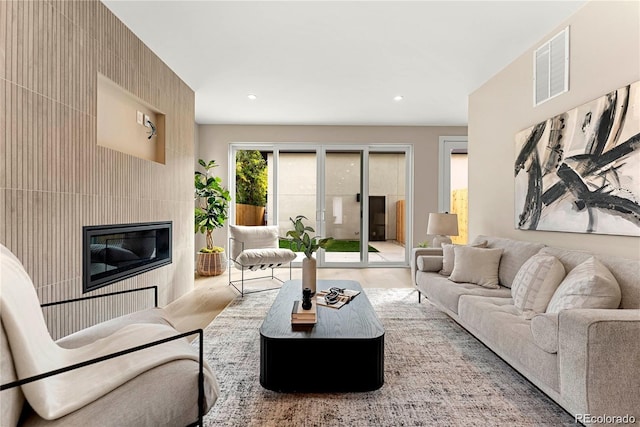 living room with visible vents, recessed lighting, and a fireplace