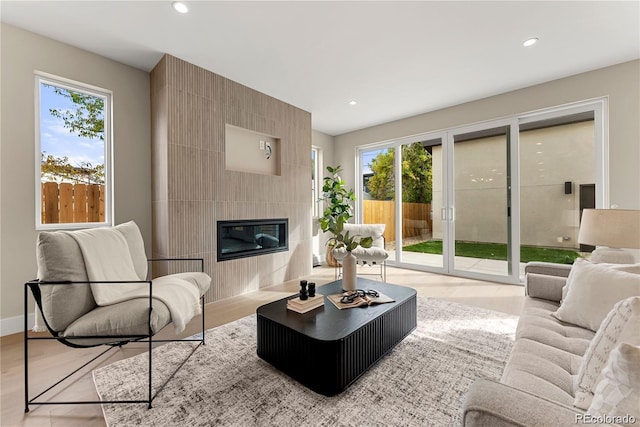 living area with plenty of natural light, recessed lighting, a tile fireplace, and baseboards