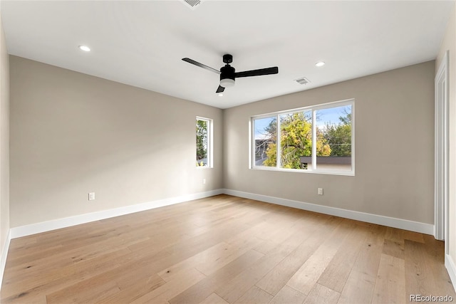 spare room featuring visible vents, ceiling fan, baseboards, and light wood-style floors