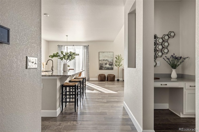 interior space featuring hardwood / wood-style flooring, sink, and a textured ceiling