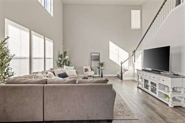 living room featuring a towering ceiling and wood-type flooring