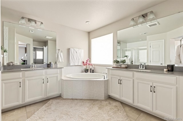 bathroom featuring parquet floors, vanity, and plus walk in shower