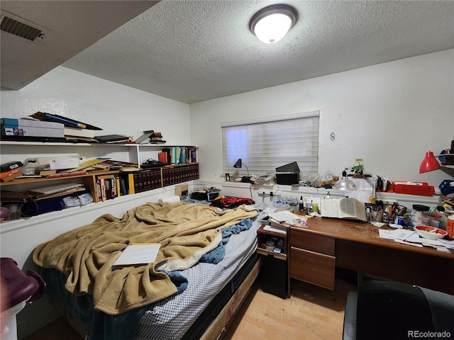 3341 E 99th Way, Thornton, CO 80229 - bedroom featuring light wood finished floors, a textured ceiling, and an office area