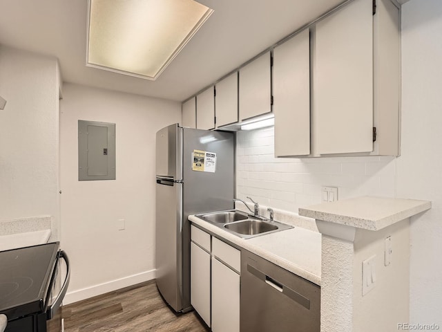 kitchen featuring dark wood-style floors, tasteful backsplash, appliances with stainless steel finishes, a sink, and electric panel