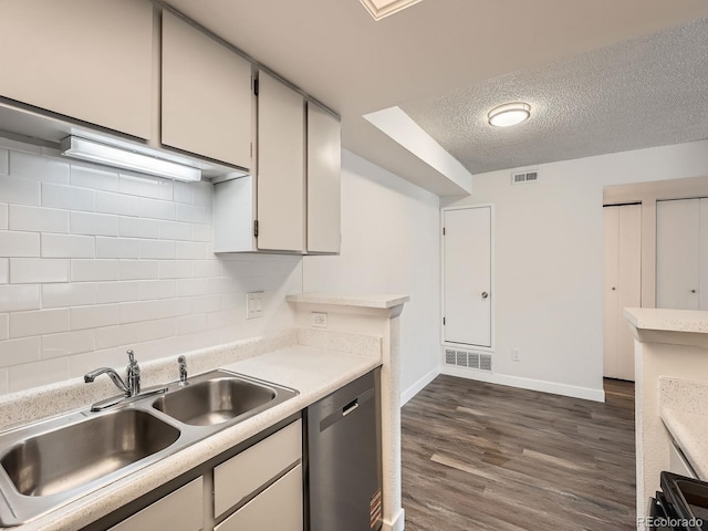 kitchen with dishwasher, tasteful backsplash, a sink, and visible vents