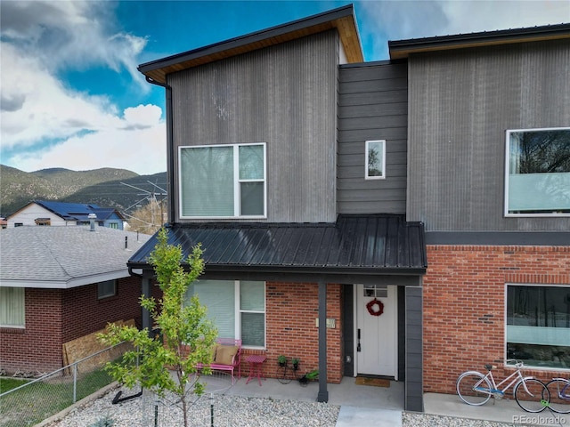 1111 E St, Salida, CO 81201 - modern home with a mountain view, brick siding, a metal roof, and a porch