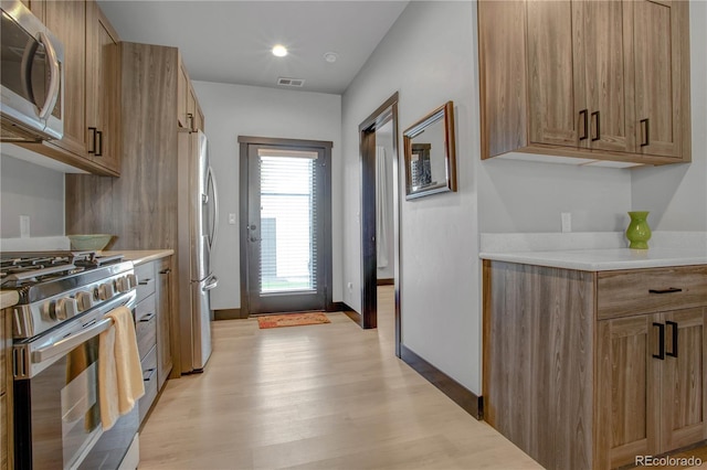 1111 E St, Salida, CO 81201 - kitchen with appliances with stainless steel finishes, light wood-style flooring, light countertops, and brown cabinets