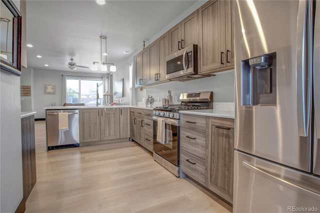 1111 E St, Salida, CO 81201 - kitchen featuring appliances with stainless steel finishes, a peninsula, light countertops, light wood finished floors, and recessed lighting