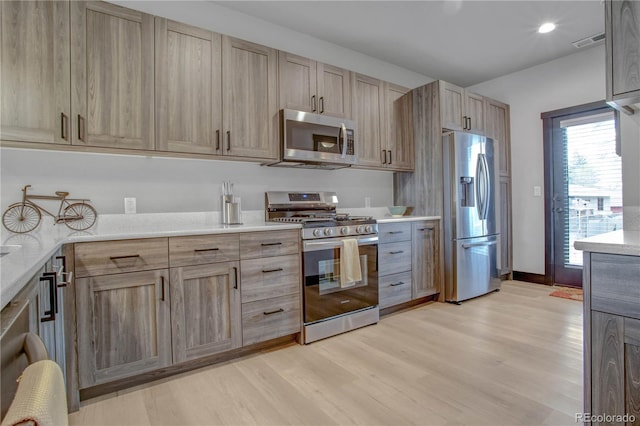 1111 E St, Salida, CO 81201 - kitchen featuring appliances with stainless steel finishes, light brown cabinetry, light wood-type flooring, light countertops, and recessed lighting