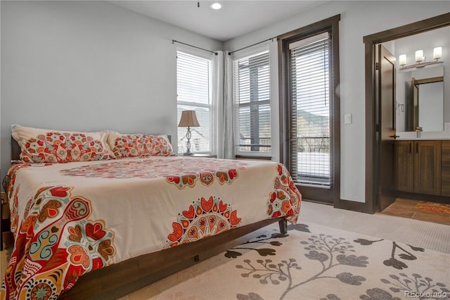 1111 E St, Salida, CO 81201 - carpeted bedroom with connected bathroom, access to outside, and recessed lighting