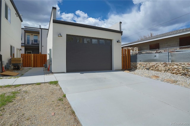 1111 E St, Salida, CO 81201 - view of front of house featuring an attached garage, concrete driveway, and stucco siding