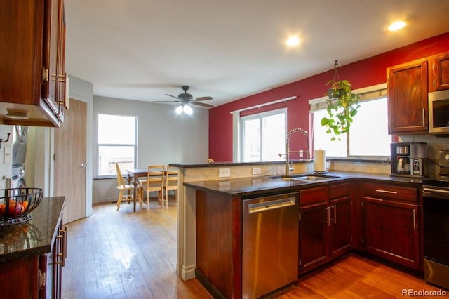 kitchen with ceiling fan, sink, a healthy amount of sunlight, dark wood-type flooring, and stainless steel appliances