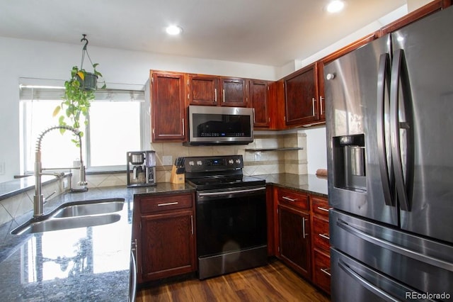 kitchen featuring dark brown cabinets, appliances with stainless steel finishes, a sink, and tasteful backsplash