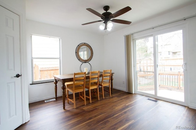 dining room featuring dark wood-style floors, visible vents, and baseboards