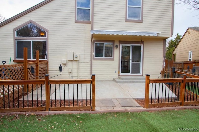 rear view of property featuring a patio area and fence