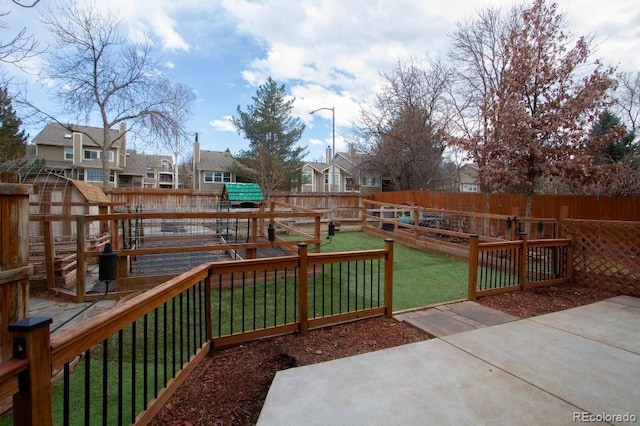 wooden terrace with a residential view, a fenced backyard, and a lawn