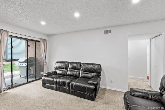 carpeted living room featuring baseboards, a textured ceiling, and visible vents