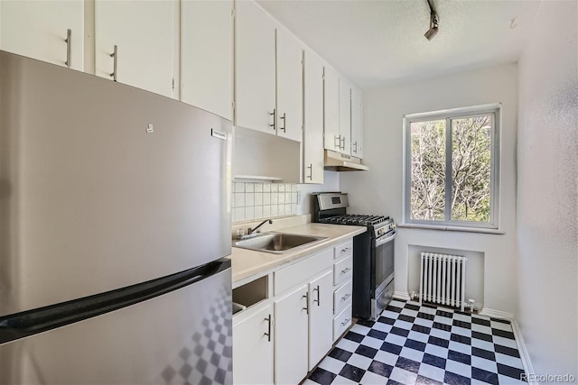 85 N Grant St Unit 22, Denver, CO 80203 - kitchen featuring appliances with stainless steel finishes, radiator heating unit, a sink, under cabinet range hood, and dark flooring