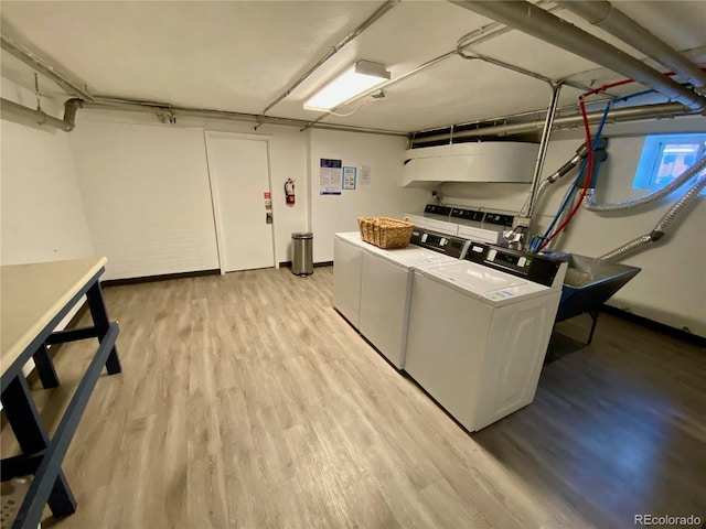 laundry area with light hardwood / wood-style floors and washing machine and dryer