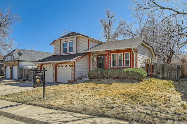 tri-level home with a front yard, fence, driveway, roof with shingles, and a garage