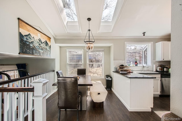 dining room with a skylight, ornamental molding, and dark wood-style flooring