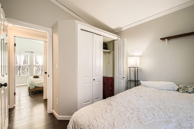 bedroom with crown molding, dark wood-style floors, a closet, and baseboards