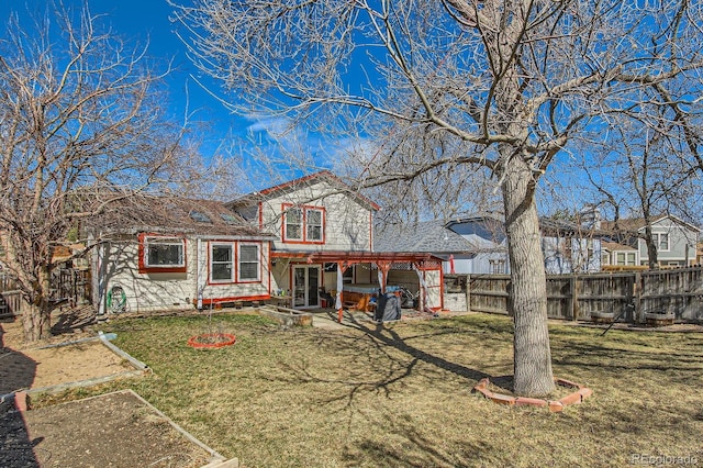 rear view of property featuring a patio area, a lawn, and a fenced backyard