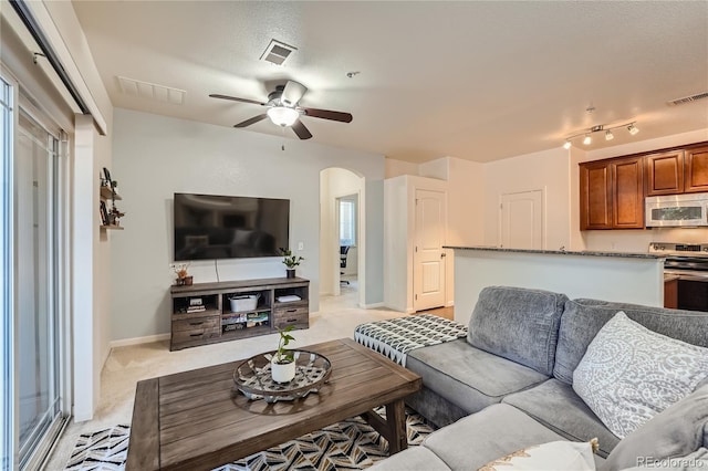 803 E 98th Ave Unit 105, Thornton, CO 80229 - living area featuring arched walkways, a ceiling fan, light colored carpet, and baseboards