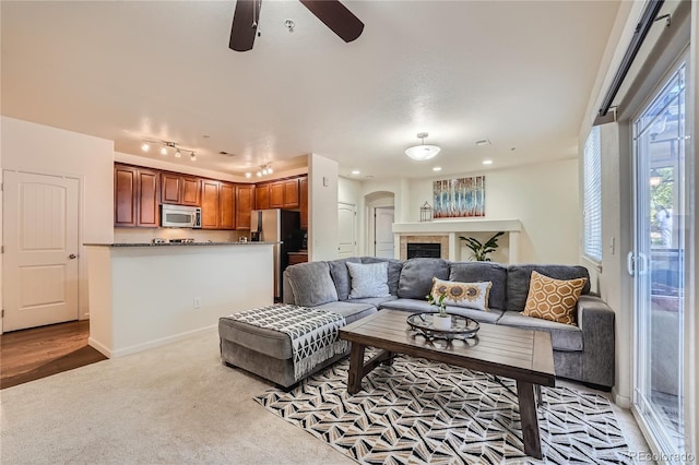 803 E 98th Ave Unit 105, Thornton, CO 80229 - living room featuring ceiling fan, arched walkways, and light colored carpet