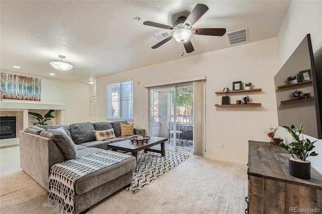 803 E 98th Ave Unit 105, Thornton, CO 80229 - carpeted living room with ceiling fan, a tile fireplace, a textured ceiling, and baseboards