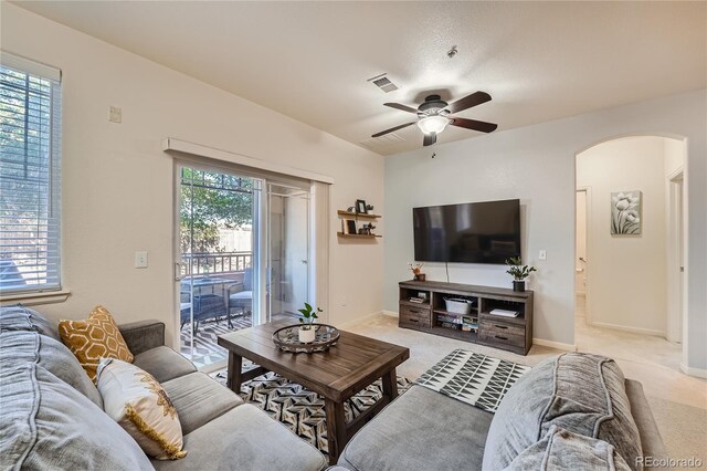 803 E 98th Ave Unit 105, Thornton, CO 80229 - living room featuring arched walkways, ceiling fan, light colored carpet, and baseboards