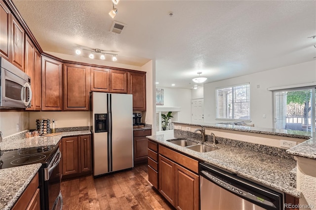 803 E 98th Ave Unit 105, Thornton, CO 80229 - kitchen with appliances with stainless steel finishes, a sink, dark wood-type flooring, light stone countertops, and a textured ceiling