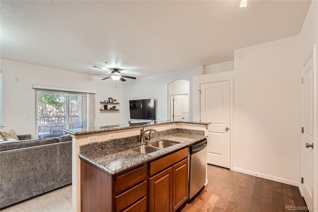 803 E 98th Ave Unit 105, Thornton, CO 80229 - kitchen with a sink, stainless steel dishwasher, open floor plan, a kitchen island with sink, and dark stone counters