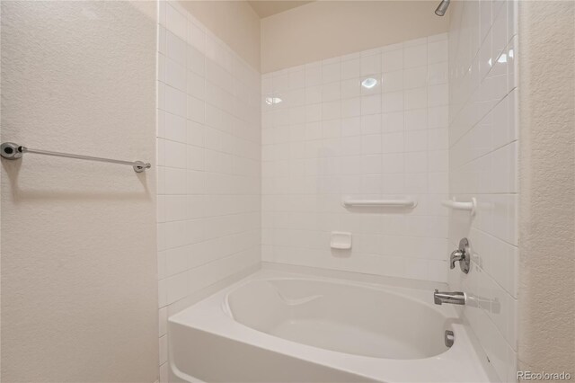 803 E 98th Ave Unit 105, Thornton, CO 80229 - bathroom featuring a textured wall and shower / bathtub combination