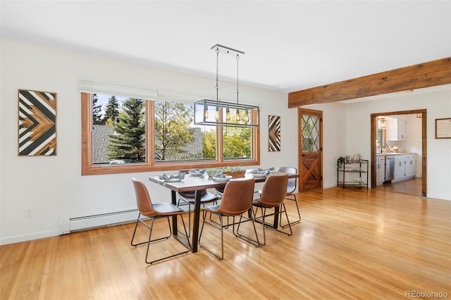 dining room with light wood-style floors, a baseboard radiator, and beam ceiling