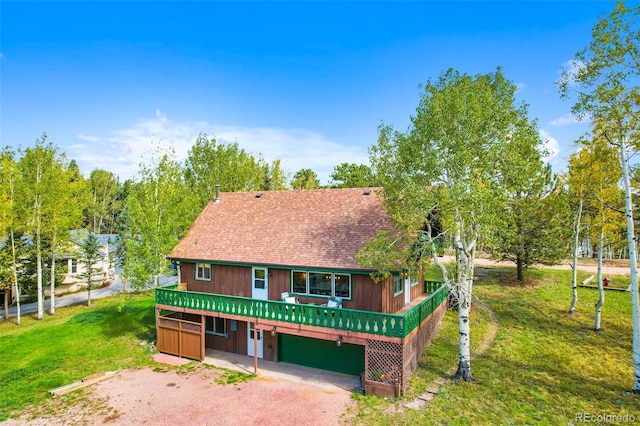 chalet / cabin featuring a front lawn, roof with shingles, a deck, and dirt driveway