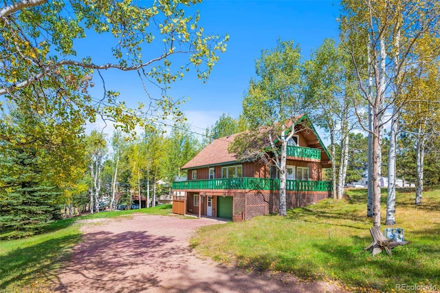 chalet / cabin featuring a front yard and dirt driveway