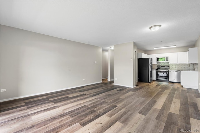 795 S Alton Way Unit 11C, Denver, CO 80247 - unfurnished living room featuring dark wood-style flooring and baseboards