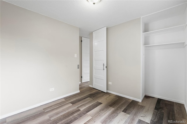 795 S Alton Way Unit 11C, Denver, CO 80247 - unfurnished bedroom with wood finished floors, a closet, and baseboards