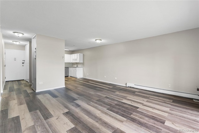 795 S Alton Way Unit 11C, Denver, CO 80247 - unfurnished living room with a sink, dark wood-style floors, baseboard heating, and baseboards