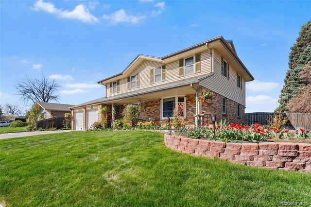 view of front of property with an attached garage, fence, a front yard, and brick siding