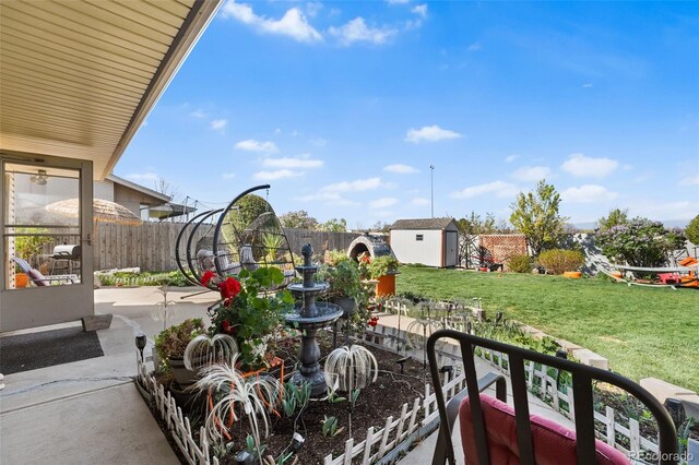 view of patio with a storage unit, a fenced backyard, and an outdoor structure