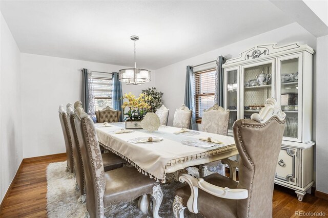dining room with an inviting chandelier, baseboards, and dark wood-style floors